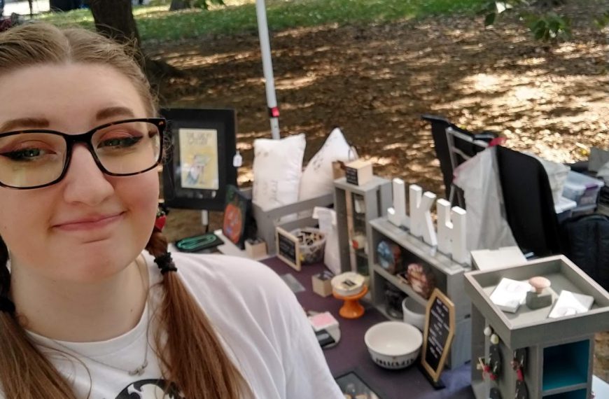 Joscelyn standing in front of the JKH Artwork booth at Art In The Park 2024